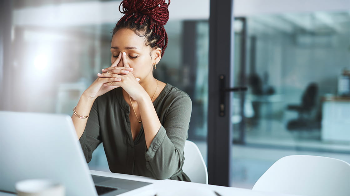 Anxious, stressed woman working at office desk