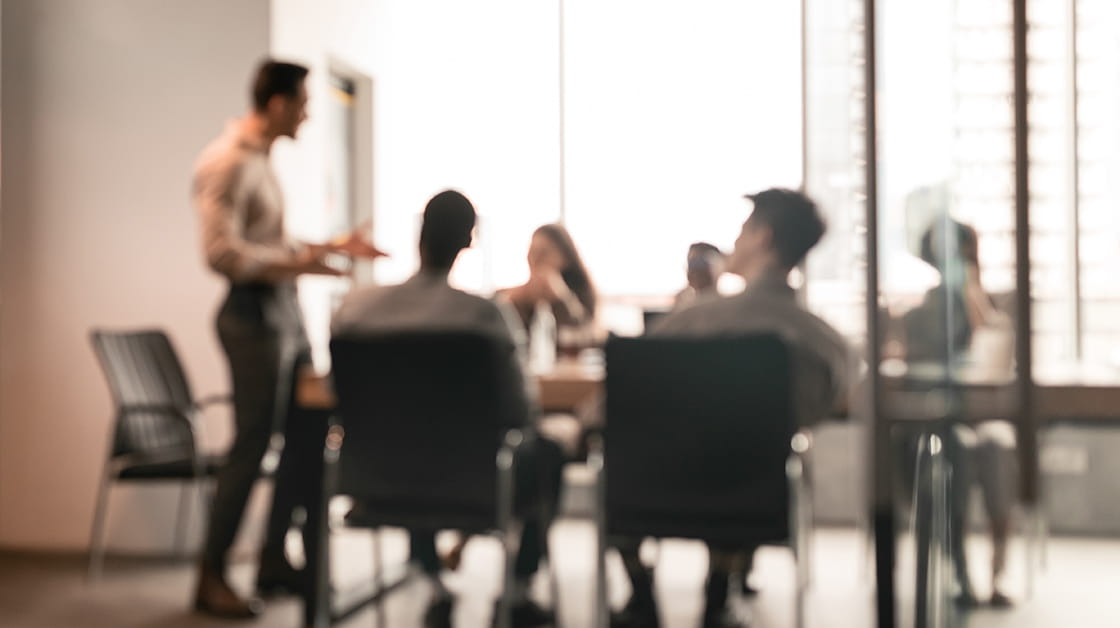 Committee members sit around meeting table