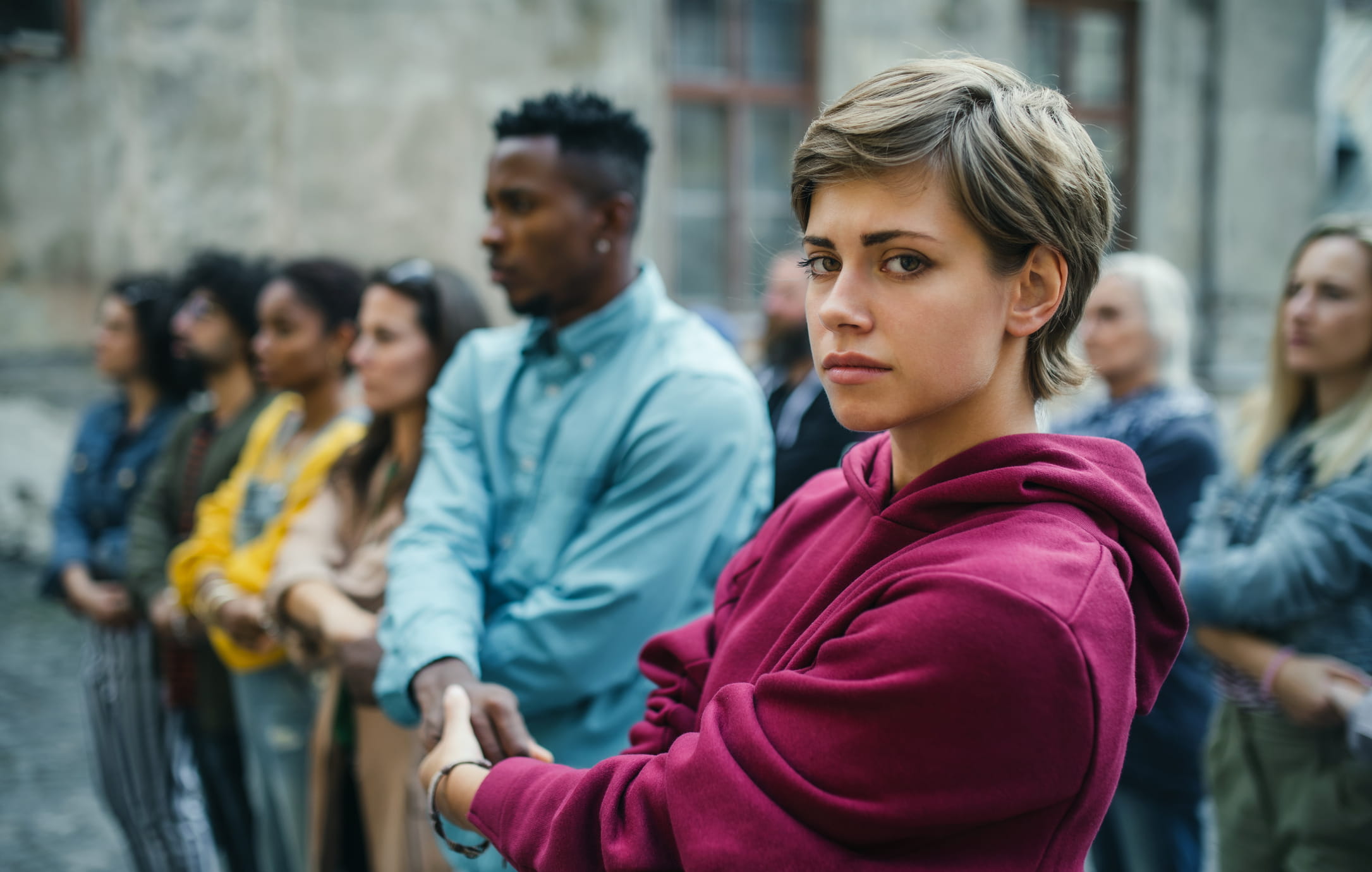 diverse-group-holding-hands-for-justice-caucasian-women-with-short-hair-looking-into-the-camera