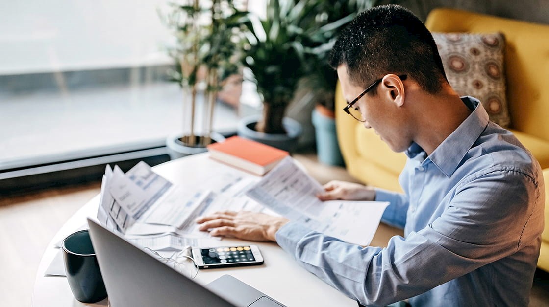 Man using calculator and laptop to give tax advice