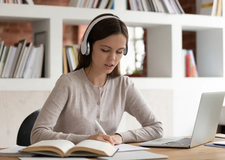 Woman working on computer writing notes