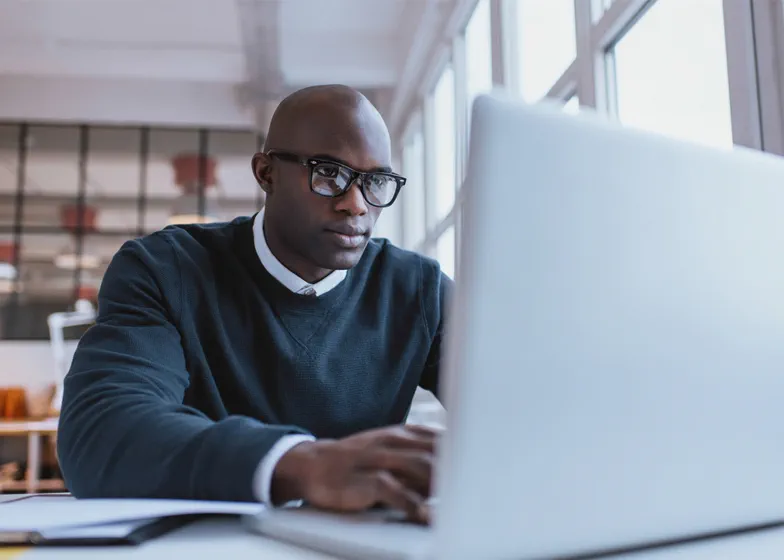 Man with glasses working on laptop