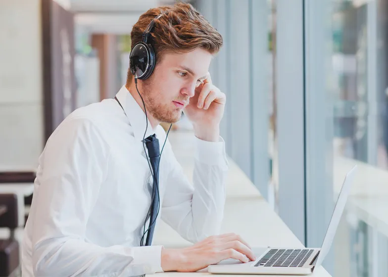 Businessman working at a computer with headphones on