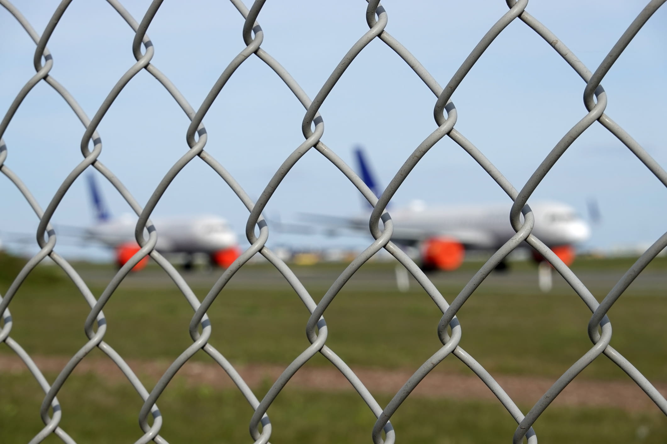 Plane on a runway behind bars