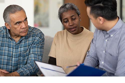 Mature couple discuss their will with lawyer at home