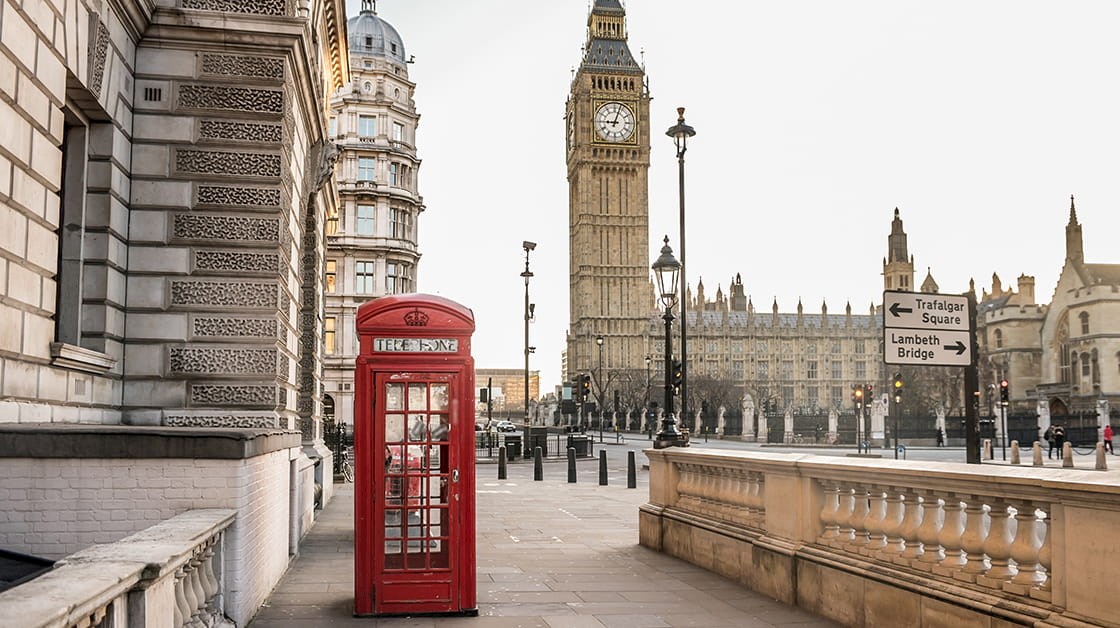 A red telephone booth outside the Houses of Parliament, London.