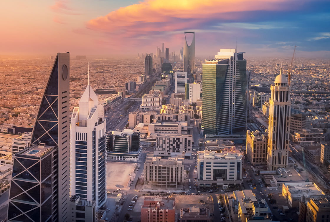 An image of the Riyadh skyline at sunset.