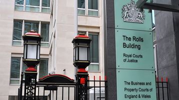 Exterior of building, sign reads: 'The Rolls Building, Royal Courts of Justice, The Business and Property Courts of England and Wales'