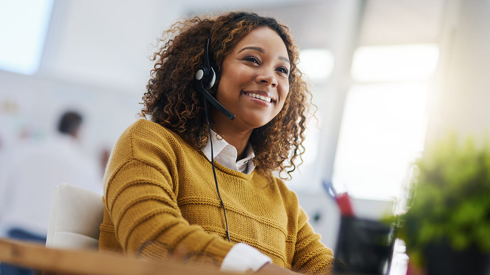 Smiling woman answering call on headset