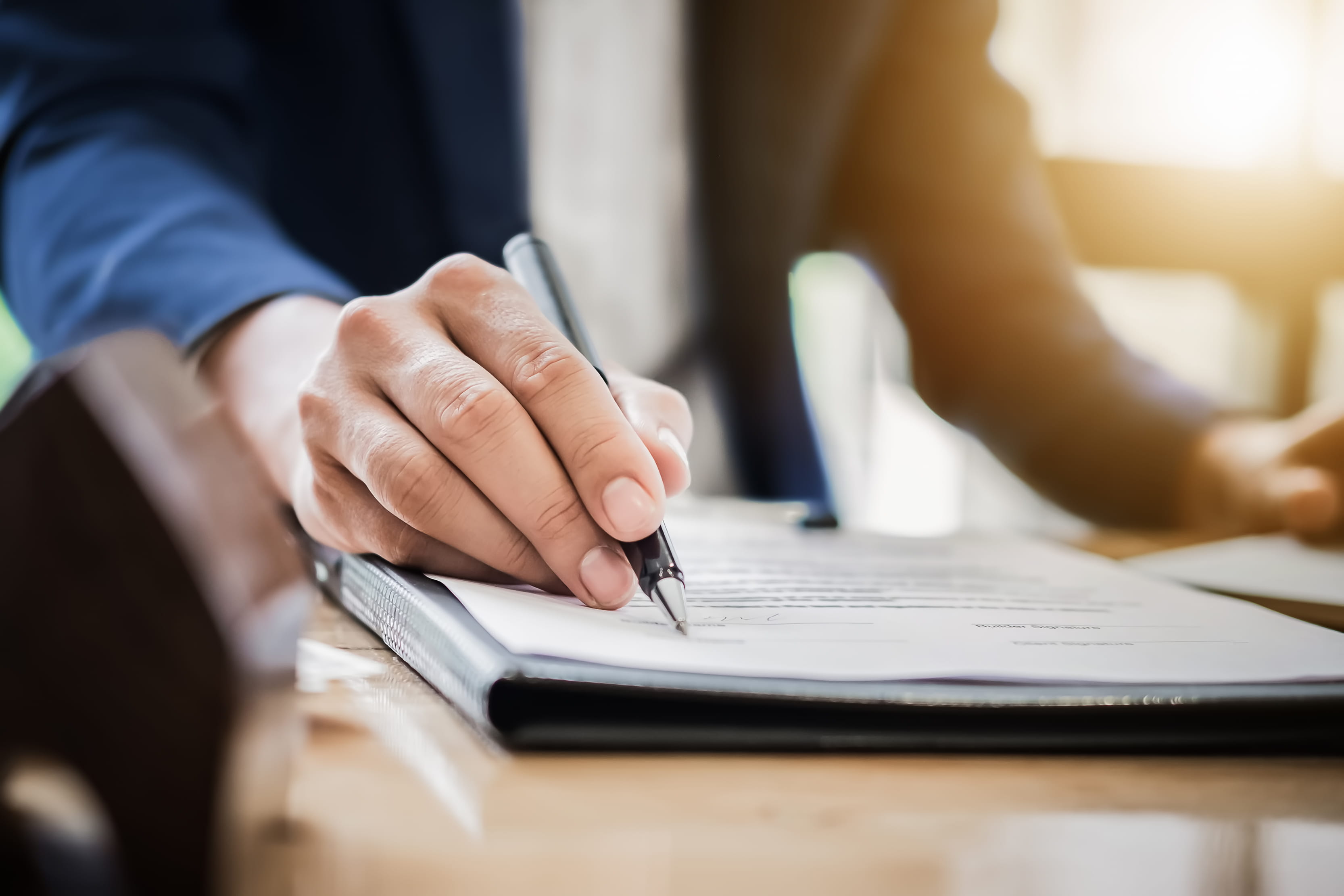 solicitor-or-professional-writing-documents-with-pen-in-hand