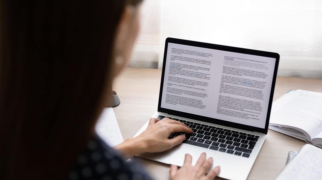 A woman edits a document on a laptop