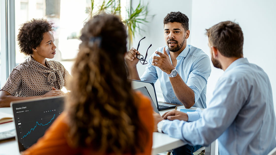 Group of young, modern people in smart casual wear discussing business while sitting in the office